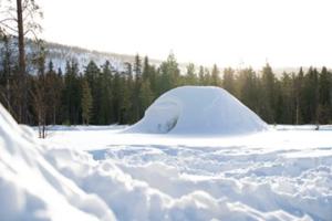 A snow fort/quinzee in the sunny winter. 